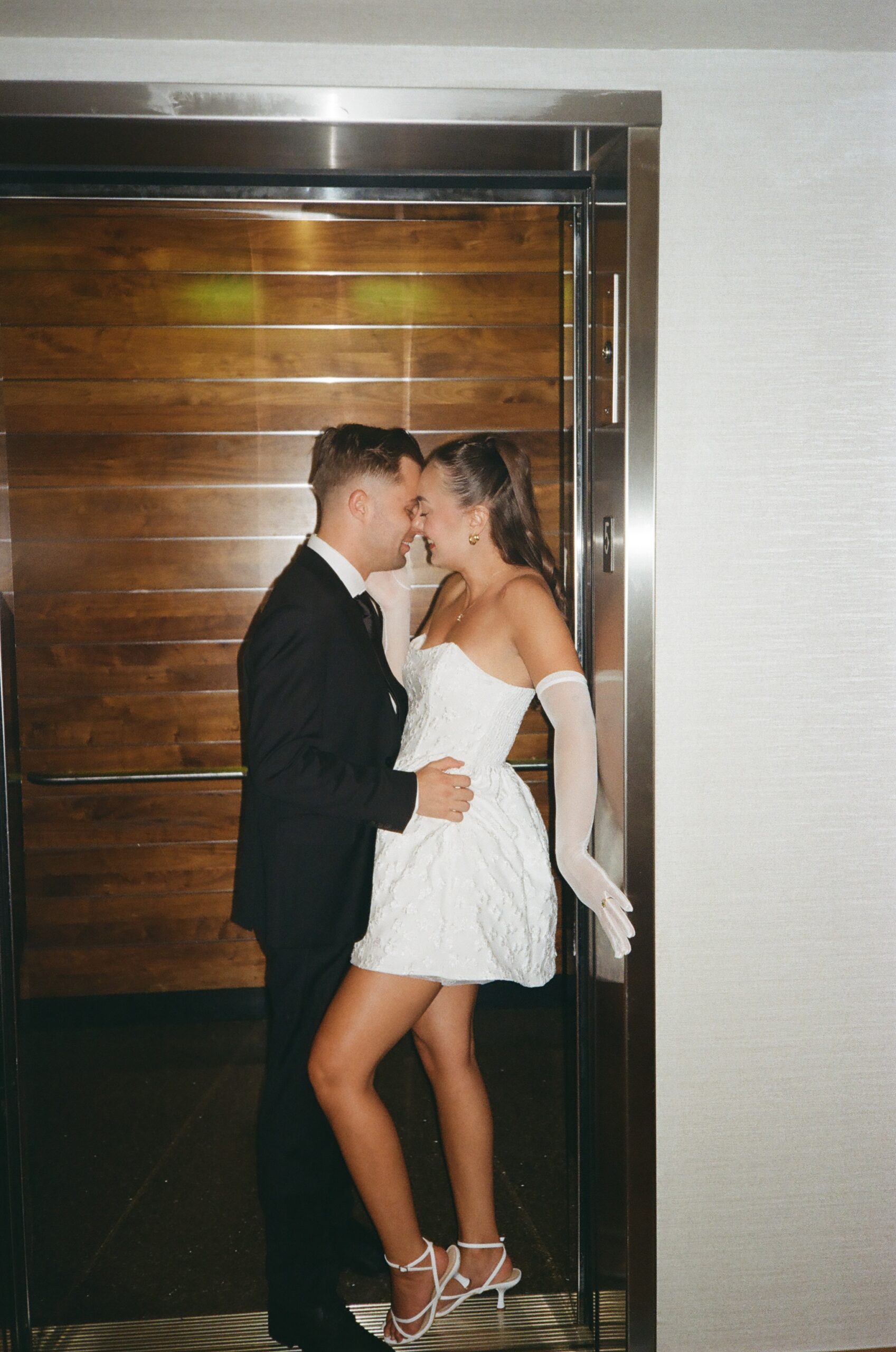 An elevator moment as the doors close during their Austin engagement session photographed on 35mm film by Austin engagement photographer.