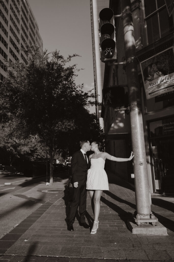 Jared and Marley standing together in downtown Austin during their engagement session, sharing a relaxed moment surrounded by city vibes.