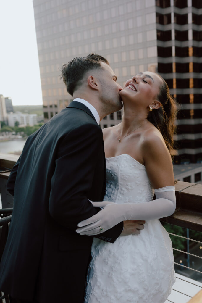 Jared making Marley laugh with a sweet moment at the rooftop during their Austin engagement session.