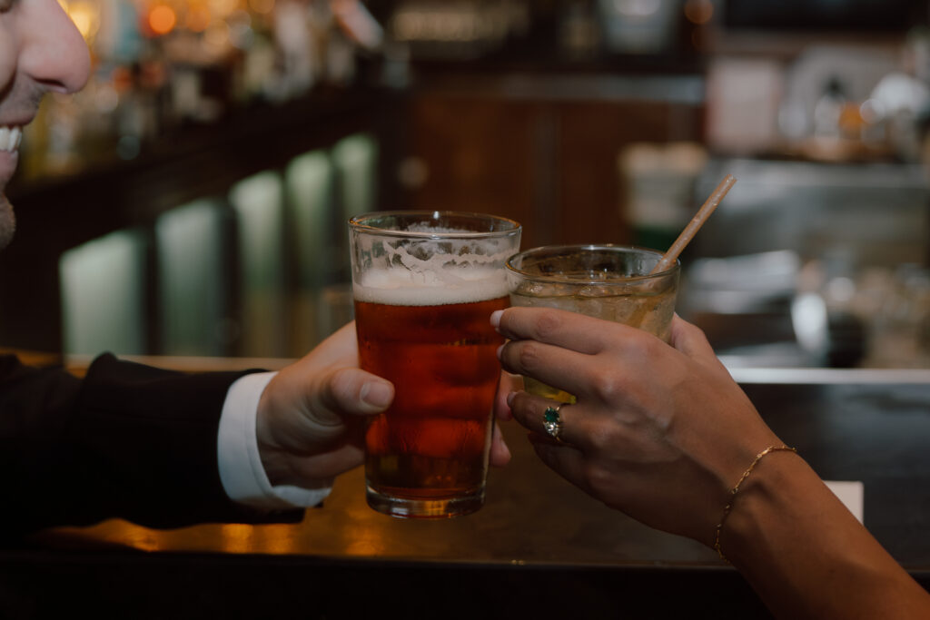 Hotel bar engagement session toast between Marley and Jared.