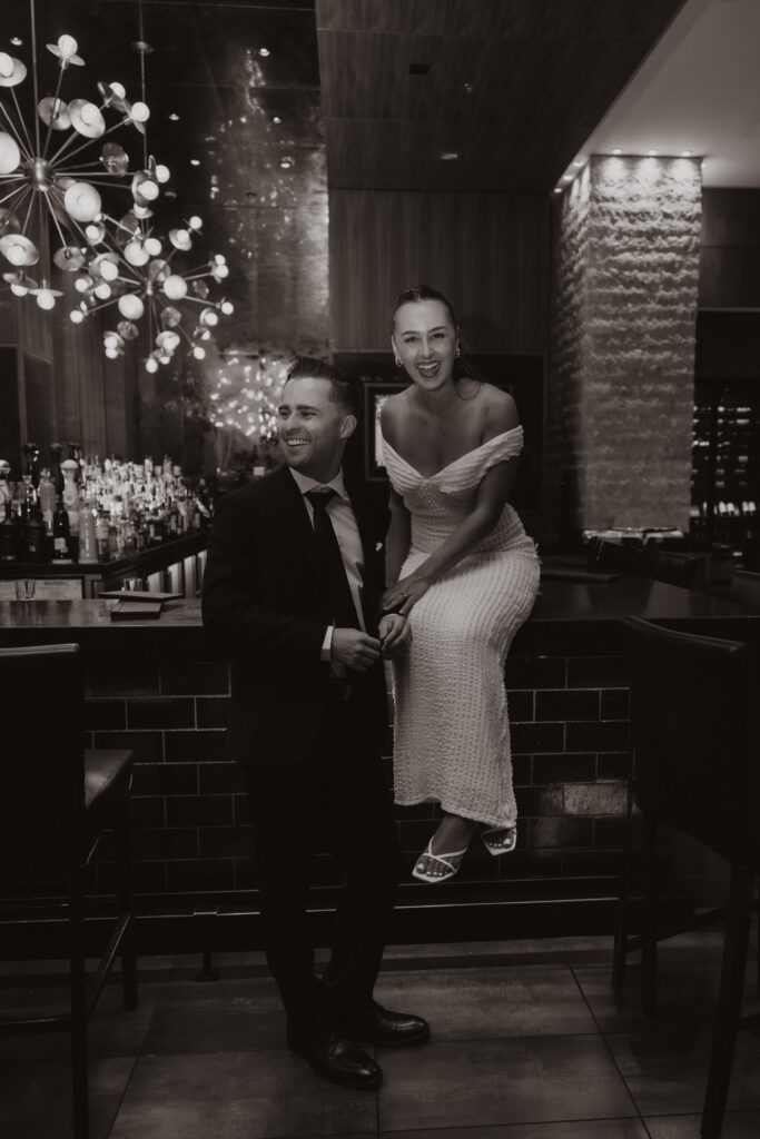 The couple sharing a romantic kiss at the hotel bar during their Austin engagement session surrounded by moody lighting and a cozy atmosphere