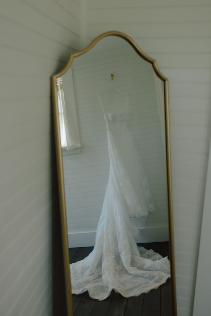 Mallory’s wedding dress hanging, showing lace and flowing fabric