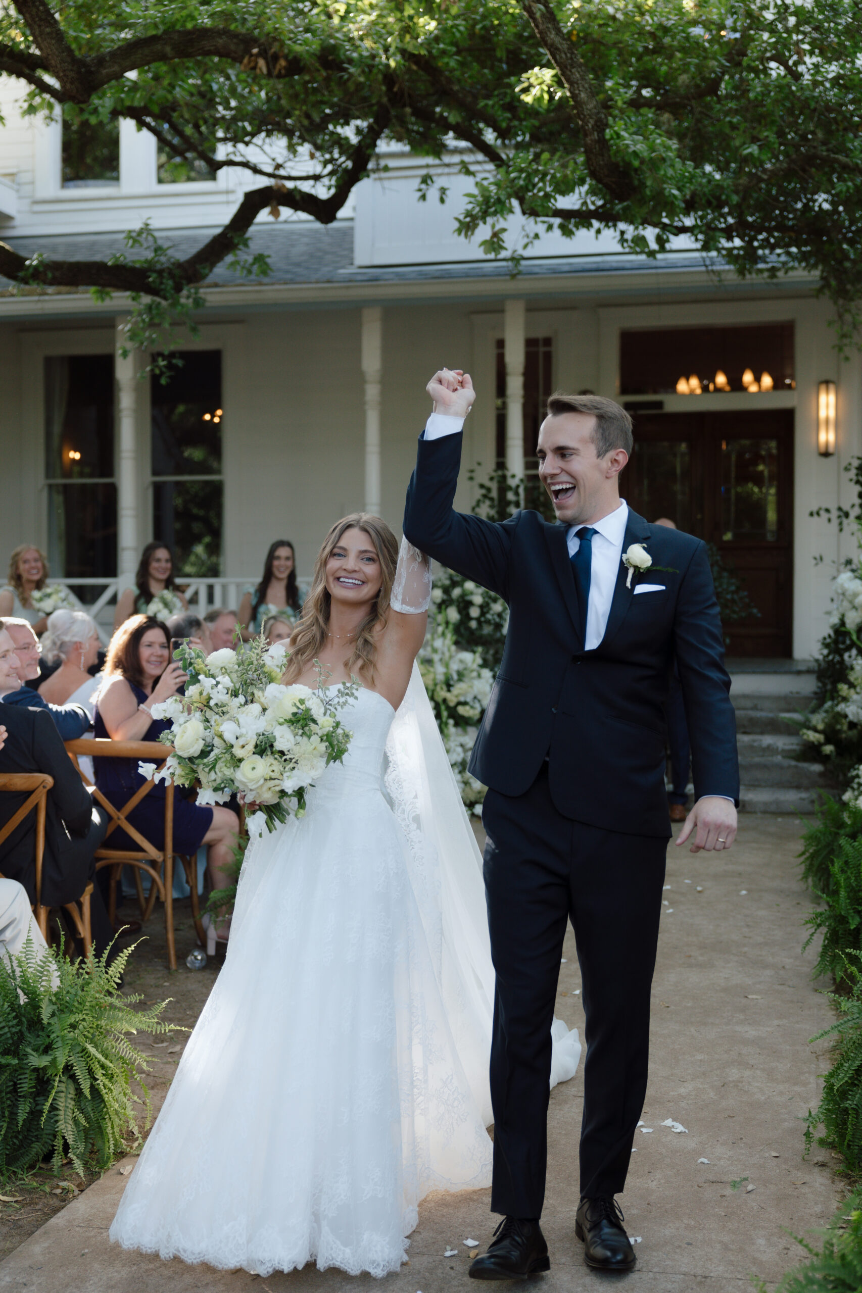 Mallory and Reese walking down the aisle at Mattie's at Green Pastures, smiling ear to ear